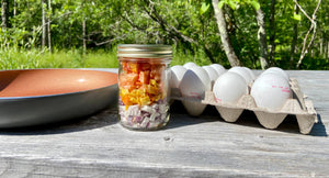 freeze-dried vegetables with eggs and a pan on a picnic bench ready for a camping breakfast